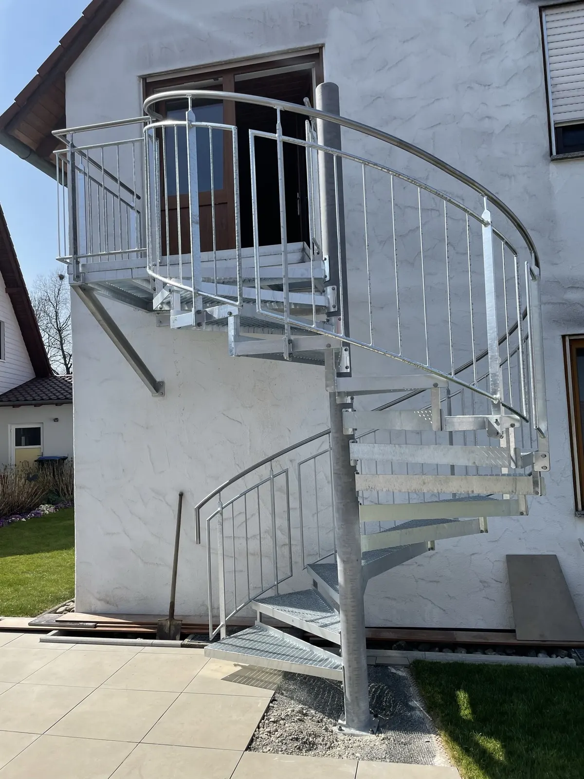 Verzinkte Außentreppe, gewendelt, an Wohnhausfassade montiert